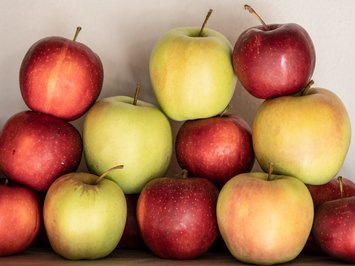 Alpine chalet in South Tyrol with a farm shop Stacked red and green apples against a light background