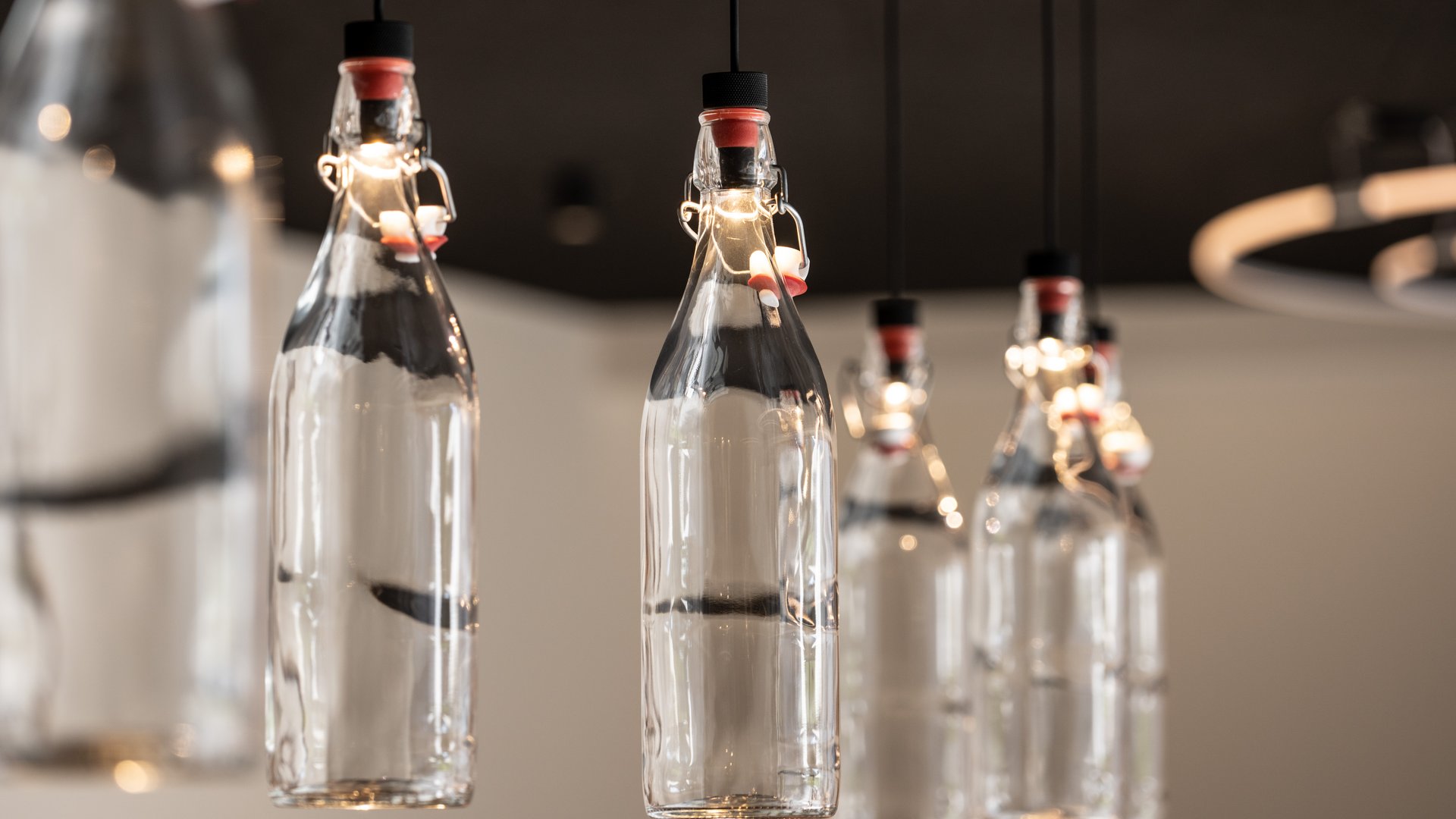 Alpine chalet in South Tyrol with a farm shop Hanging lights made from transparent glass bottles in a row