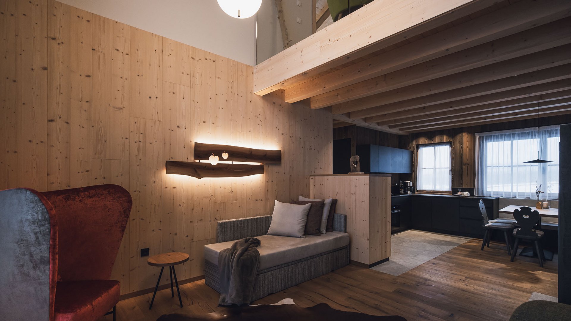 Urlaub in Natz-Schabs? Kessler’s Mountain Lodge! Gemütlicher Holzraum mit Lounge, Stehlampe und moderner Küche