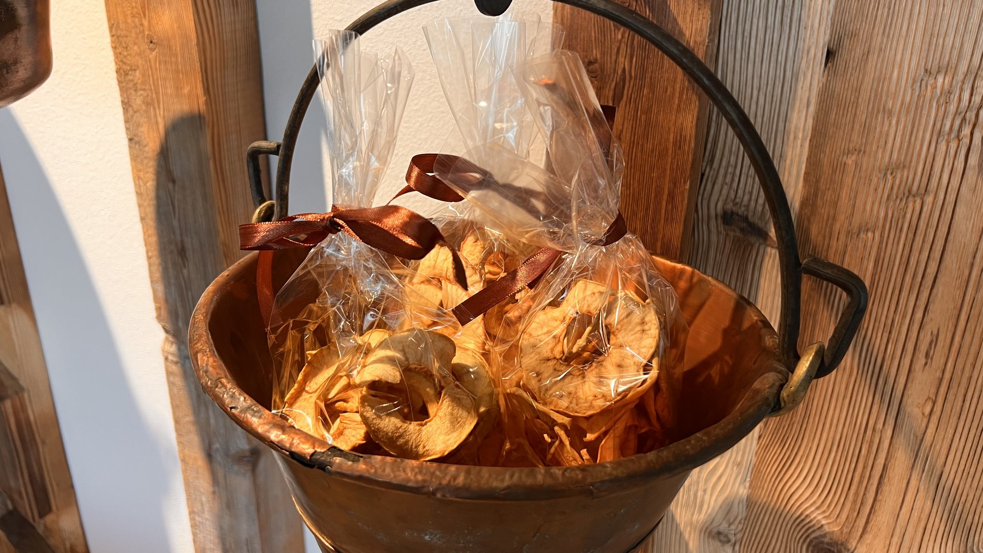 Alpine chalet in South Tyrol with a farm shop Dried apple slices in plastic bags with brown ribbons in a copper pot
