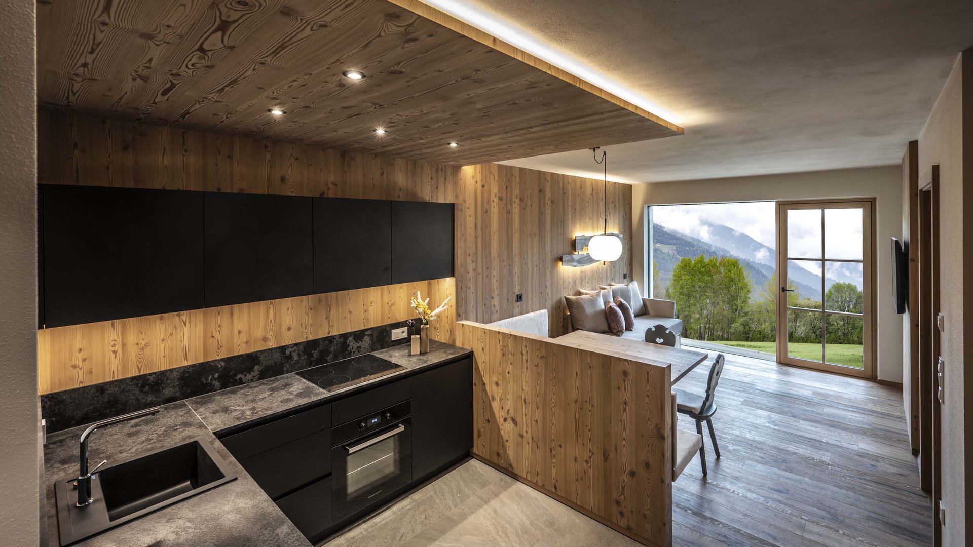 Urlaub in Natz-Schabs? Kessler’s Mountain Lodge! Moderne Küche mit Holzverkleidung und Aussicht auf grüne Berge