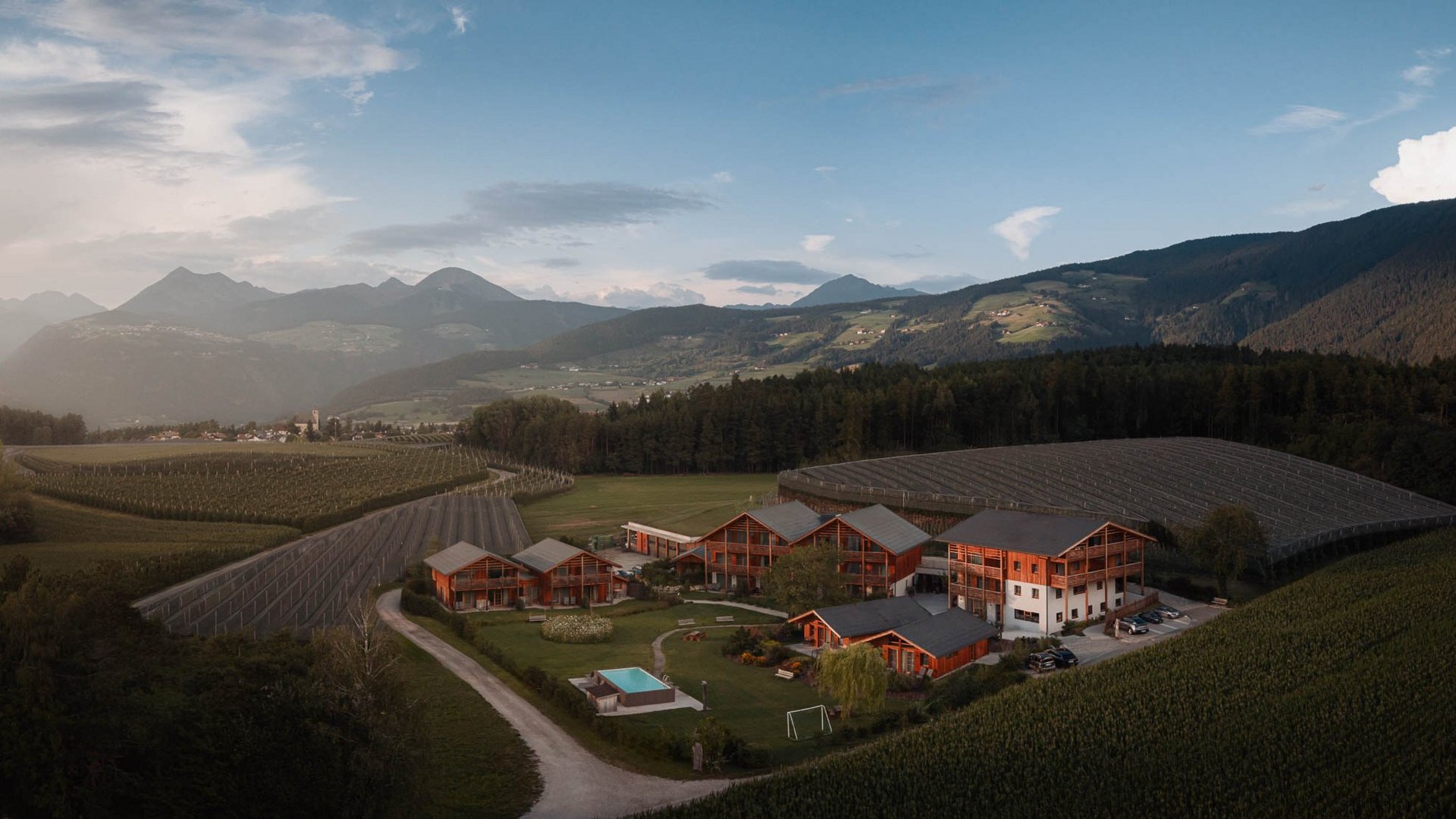 Urlaub in Natz-Schabs? Kessler’s Mountain Lodge! Ferienanlage mit Holzhäusern und Pool inmitten von Feldern und Bergen
